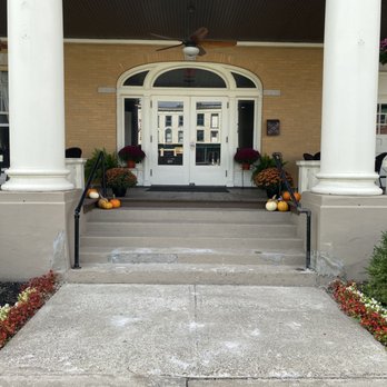 Front entrance with fall decorations including pumpkins, mums, and autumn planters