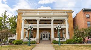 Clean front-on shot of hotel facade with warm yellow brick and white columns