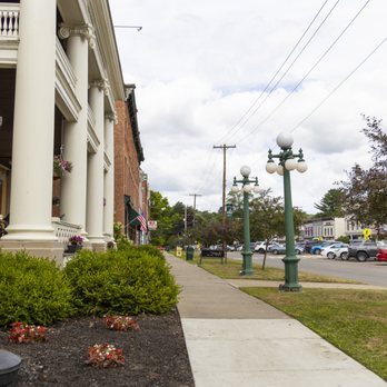View along sidewalk past hotel columns with globe lampposts