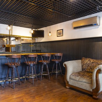 Tap Room bar with leather stools, dark wood, and tin ceiling