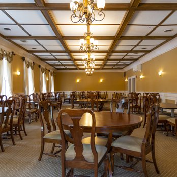 Dining room with ornate chandeliers and formal table settings