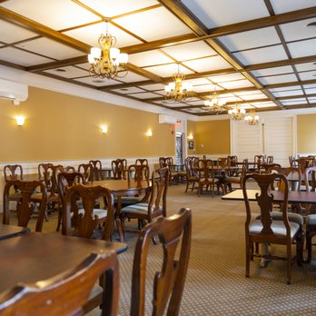 Dining room with tables, chandeliers, and gold walls