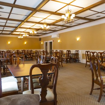 Grand Dining Room with coffered ceilings, crystal chandeliers, gold walls, and formal table settings for up to 100 guests