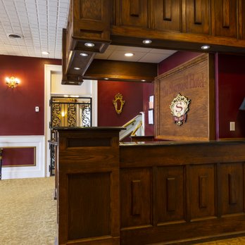 Oak front desk with carved Sherwood Hotel sign and ornate crest