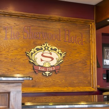 Carved oak sign reading The Sherwood Hotel with ornate S crest and Est. 1913 below