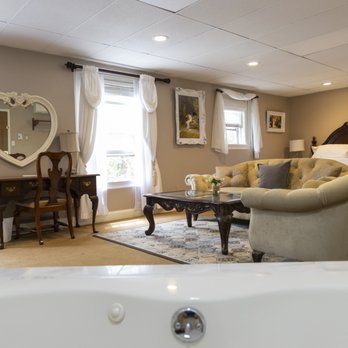 View from the jacuzzi tub looking into the bridal suite with vanity, sitting area, and bed