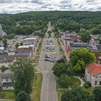 Stunning aerial looking down Main Street with tree-lined boulevard, historic buildings, and hills fading into the distance